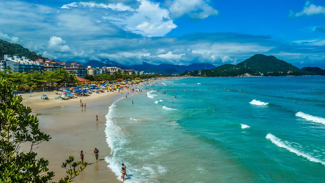 Praia Grande de Ubatuba vista do alto, com faixa de areia extensa e prédios ao fundo